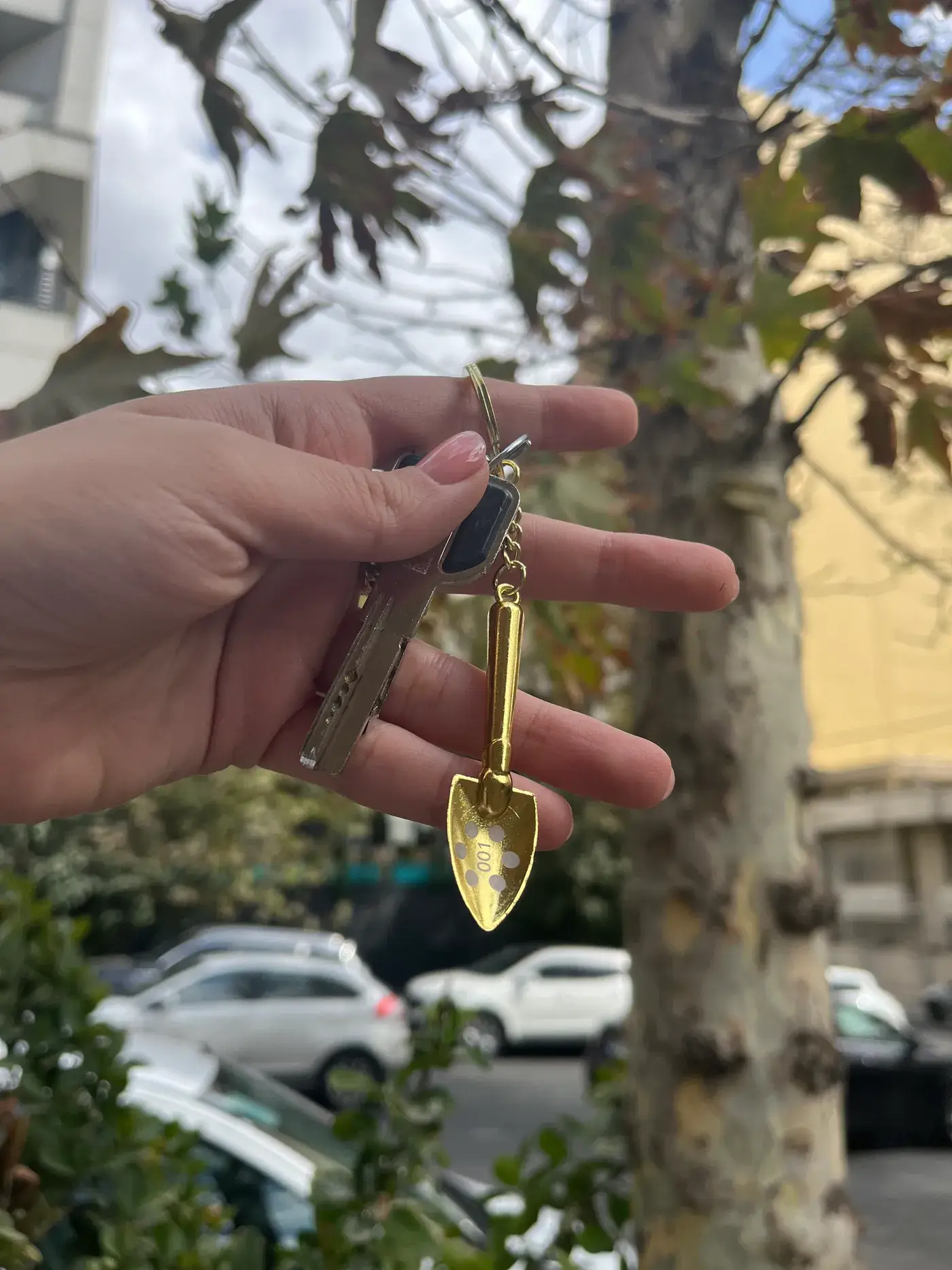 Gold shovel keychain held in hand