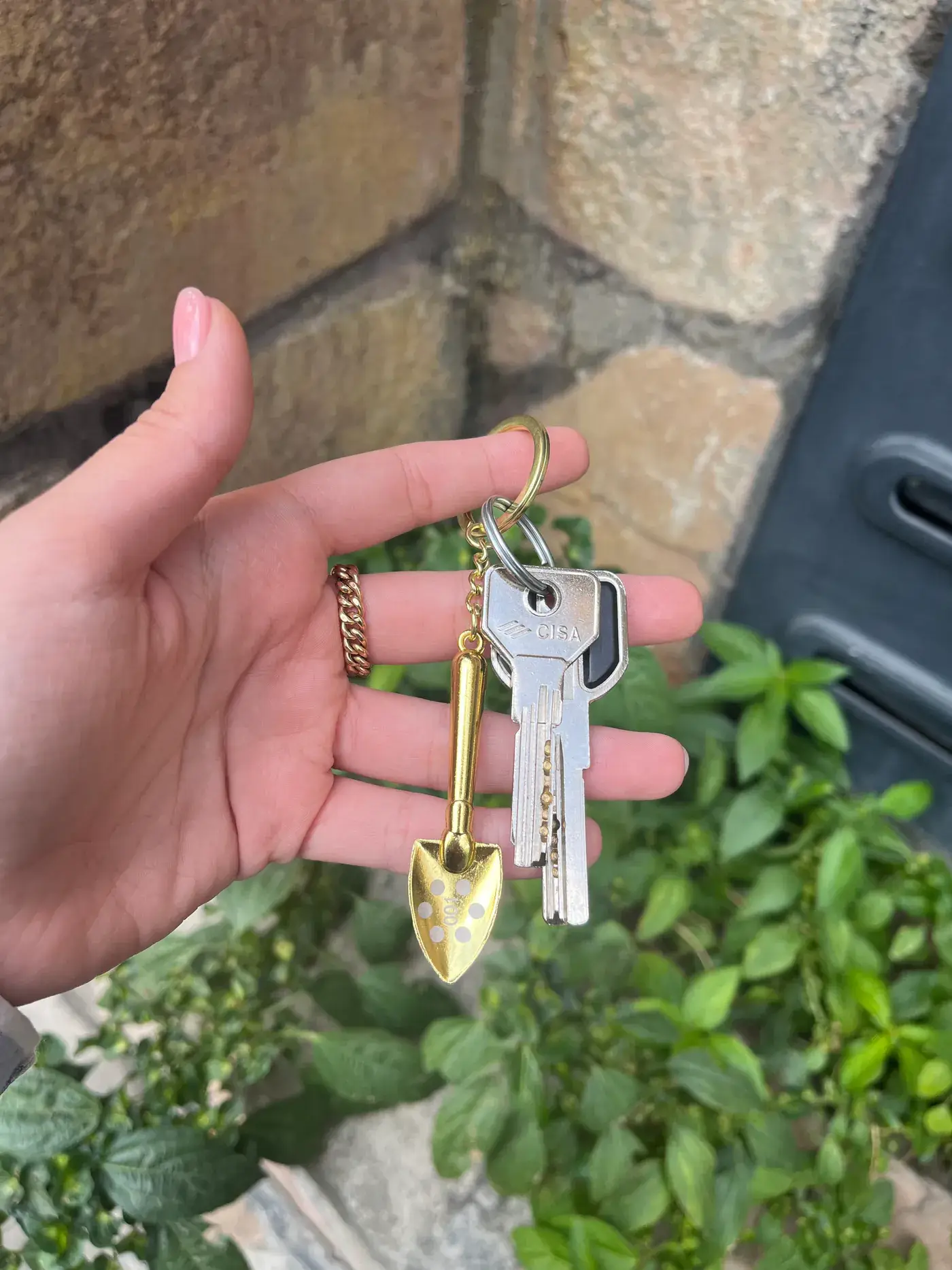 Gold shovel keychain held in hand