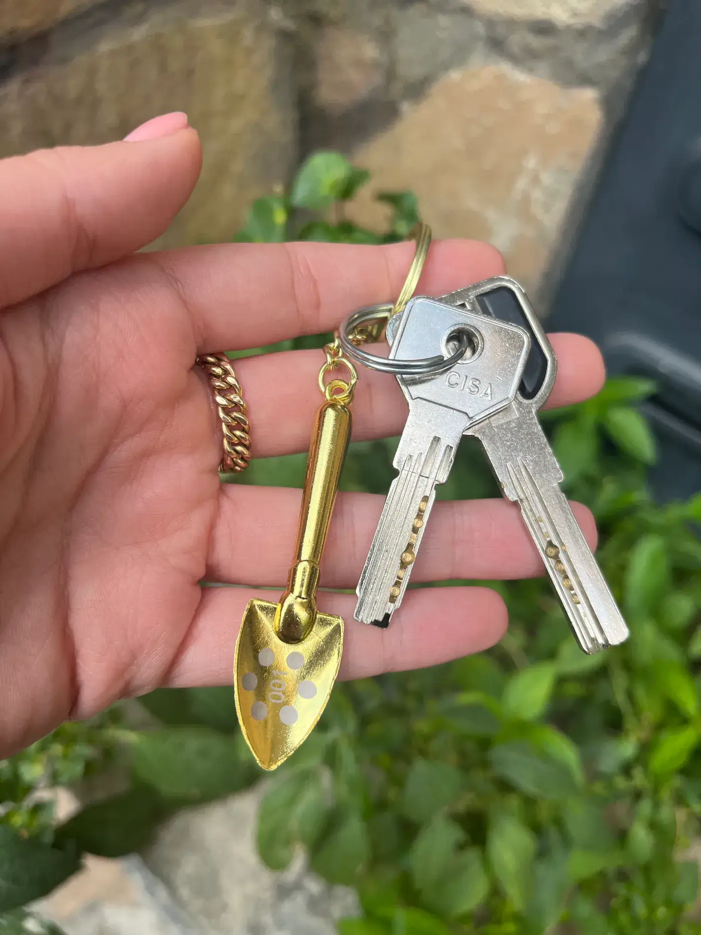Gold shovel keychain held in hand